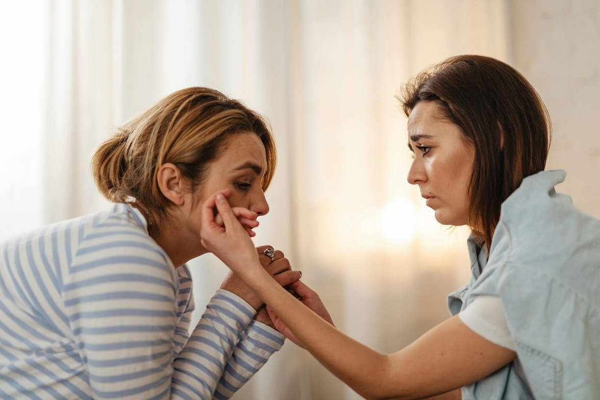 woman helping , supporting through wiping tears of face